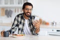 Smiling middle-eastern man eating healthy food and using phone Royalty Free Stock Photo