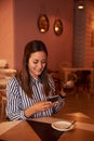 Smiling millenial in restaurant with tea