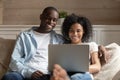 Happy african American couple relax on couch using laptop Royalty Free Stock Photo