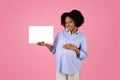 Smiling millennial african american curly pregnant woman in casual touching big belly, show banner Royalty Free Stock Photo