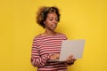 Smiling millennial african american woman working on laptop Royalty Free Stock Photo