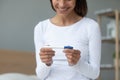 Smiling millennial biracial woman holding plastic test in hands. Royalty Free Stock Photo