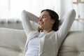 Happy girl relax on comfortable couch at home dreaming Royalty Free Stock Photo