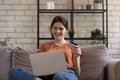 Smiling millennial european female bank client involved in online shopping.