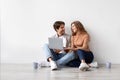 Smiling millennial european man and woman sitting on floor resting from moving at new house, planning interior Royalty Free Stock Photo