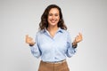 Smiling millennial european woman enjoy success in work, business, show love sign with hands