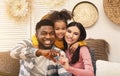 Smiling millennial family on sofa at home