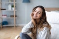 Smiling millennial girl sitting in a cozy chair at home