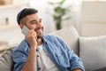 Smiling millennial man talking on phone at home Royalty Free Stock Photo