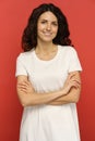 Smiling millennial woman with crossed hands look in camera dressed in white with natural curly hair Royalty Free Stock Photo