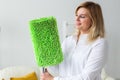 Smiling millennial woman housewife with mop for washes floor enjoys cleaning in minimalist interior. Household cleaning