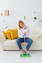 Smiling millennial woman housewife with mop for washes floor enjoys cleaning in minimalist interior. Household cleaning