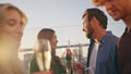 Smiling millennials drinking sparkling wine at rooftop party hangout close up. Royalty Free Stock Photo