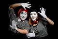 Smiling mimes in striped shirts. Man and woman, dressed as actors