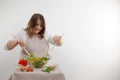 Smiling mixed nationality woman stirring vegetable salad with wooden spoon while smiling in kitchen. Houselife and Royalty Free Stock Photo