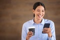 Smiling mixed race businesswoman isolated against a brown background with copyspace and using a cellphone to browse the