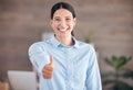 Smiling mixed race businesswoman standing alone and using hand gestures to make a thumbs up. Confident and ambitious