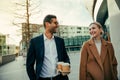 Smiling mixed race colleagues bonding while walking to work enjoying hot coffee and brainstorming ideas Royalty Free Stock Photo