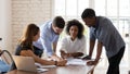 Smiling mixed race colleagues explaining project ideas to female teammates. Royalty Free Stock Photo