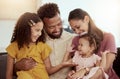 Smiling mixed race parents enjoying weekend with two adorable daughters in home living room. Hispanic girls and siblings Royalty Free Stock Photo