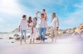 A smiling mixed race three generation family with little girls walking together on a beach. Adorable little kids bonding Royalty Free Stock Photo