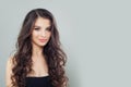 Smiling mode brunette woman with natural makeup and long wavy hair on gray banner background