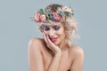 Smiling model in flowers. Beautiful young woman with short blonde curly hair and bright makeup Royalty Free Stock Photo