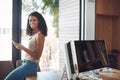 Smiling, modern and casual female in her home office happy to be working remote. Portrait of a confident young online Royalty Free Stock Photo