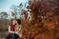 smiling modern couple in park kissing while sitting on bench Royalty Free Stock Photo