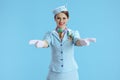 smiling modern female air hostess on blue gesturing Royalty Free Stock Photo