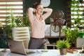 smiling modern female employee at work with electric fan