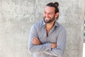 Smiling modern man with beard standing with arms crossed