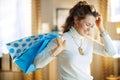 Smiling modern middle age housewife with blue shopping bags