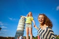 Smiling modern mother and daughter posing for tourist picture