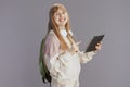 smiling modern pupil in beige tracksuit with backpack