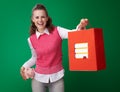 Student woman with piggy bank giving shopping bag with books Royalty Free Stock Photo