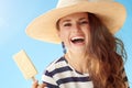 Smiling modern woman against blue sky with ice cream on stick Royalty Free Stock Photo