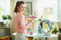 Smiling modern woman with iron and clothes basket ready to iron Royalty Free Stock Photo