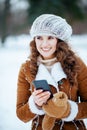 Smiling modern woman sending text message using smartphone Royalty Free Stock Photo