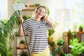 Smiling woman in striped shirt in sunny day housecleaning