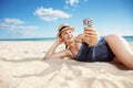 Smiling modern woman taking selfie with phone on seacoast Royalty Free Stock Photo