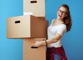 Smiling modern woman holding pile of cardboard boxes on blue Royalty Free Stock Photo