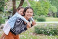 Smiling mom carrying her little child girl in garden with fully fall pink flower around. Happy loving family Royalty Free Stock Photo