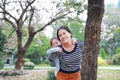 Smiling mom carrying her little child girl in garden with fully fall pink flower around. Happy loving family Royalty Free Stock Photo