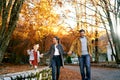 Smiling mom and dad walking with little girl holding hands on the road in the park Royalty Free Stock Photo