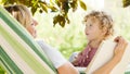 Smiling mom reading a story from the book to the little girl daughter child blue eyes with blond curly hair, together lying on the Royalty Free Stock Photo