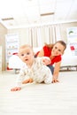 Smiling mommy playing with creeping on floor baby