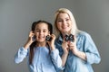 Smiling mommy and preschool daughter make word Mama playing with ABCs, closeup in soft focus of hands holding letters