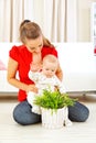 Smiling mommy showing plant to her baby