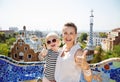 Smiling mother and baby at Park Guell showing thumbs up Royalty Free Stock Photo